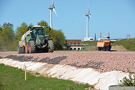 Un tractor circula por una carretera de construcción provisional