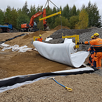 Empleados colocando la estera de absorción de aceite Tektoseal Active con un travesaño de colocación